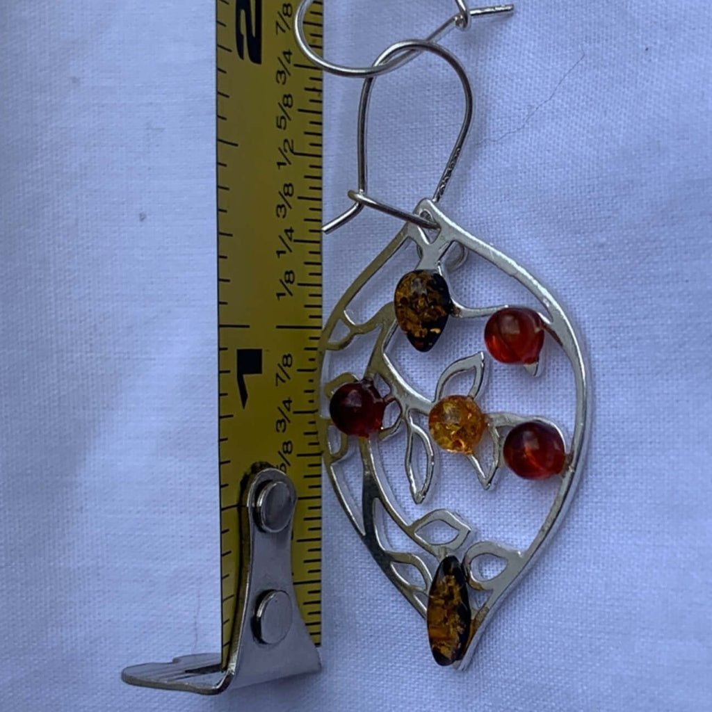 Sterling silver drop dangle earrings with 6 amber stones in leaf design next to a measuring tape showcasing their size.