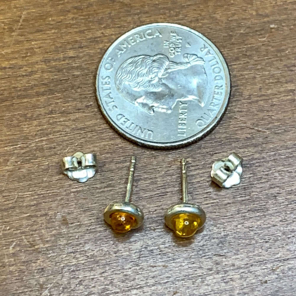 Sterling silver 925 women's round cognac amber stud earrings next to a quarter for size comparison.