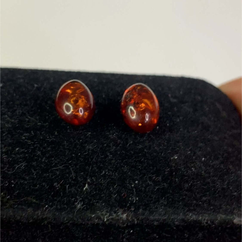 Sterling Silver 925 Cognac Amber Stud Earrings with Freestanding Oval Stones Showcasing Stunning Colors on Black Background