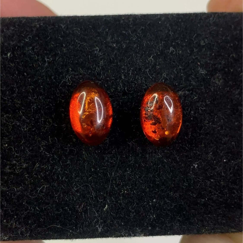 Sterling silver 925 cognac free-standing oval stud earrings featuring beautiful colors against a black background.