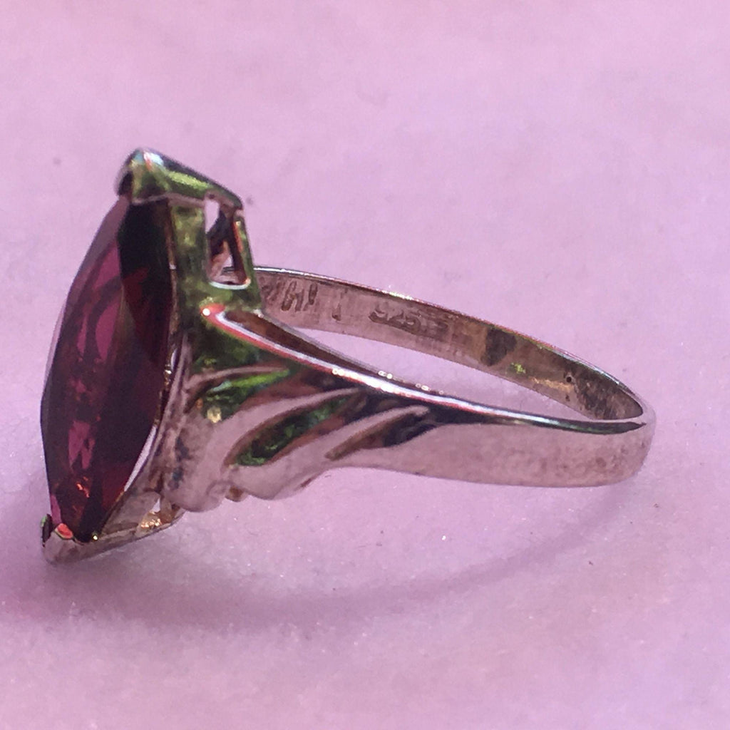 curving accents and on each side of the band which accent the garnet nicely