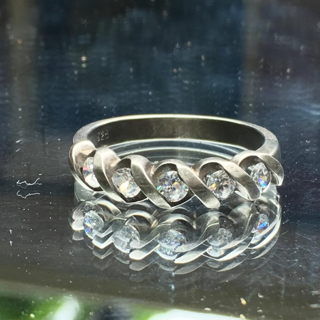Sterling silver ring in size 9 with 5 simulated diamonds running across the face of the ring.